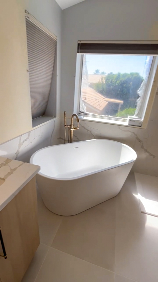 Bathroom with floating vanity, modern faucet, and warm wood accents
