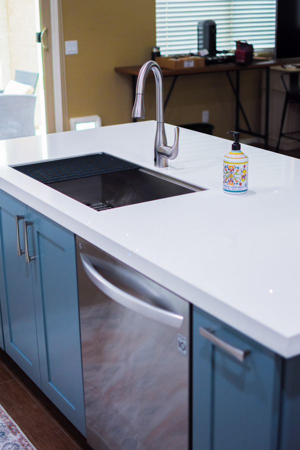 Completed kitchen remodel with island seating, pendant lighting, and clean material palette
