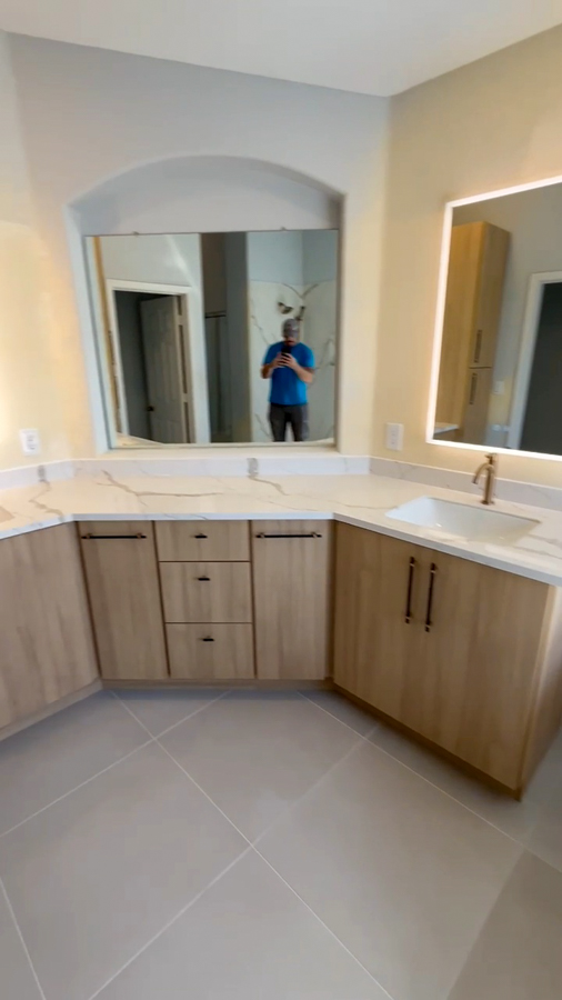 Bathroom remodel with dual vanities, quartz tops, and a backlit mirror