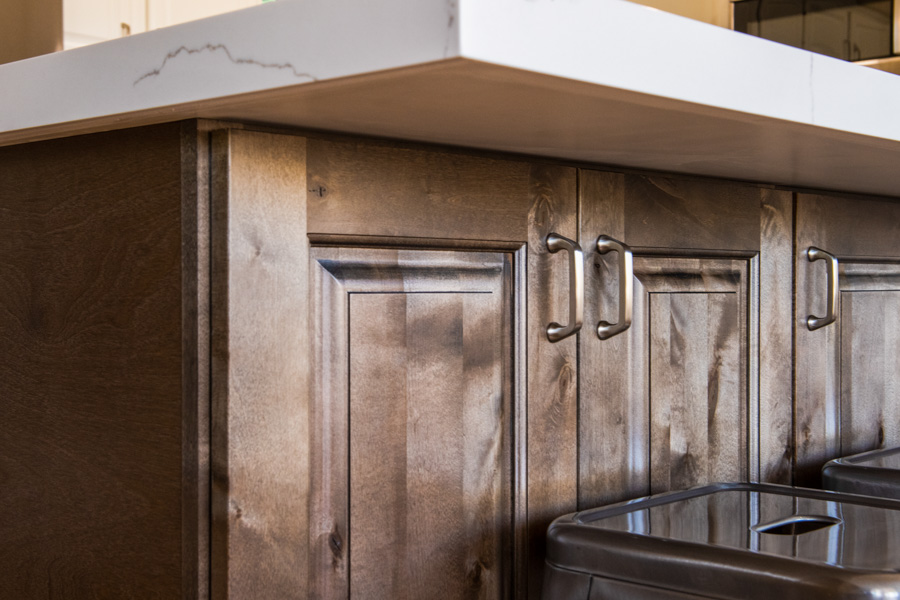 Kitchen with custom cabinetry, quartz countertops, and warm pendant lighting